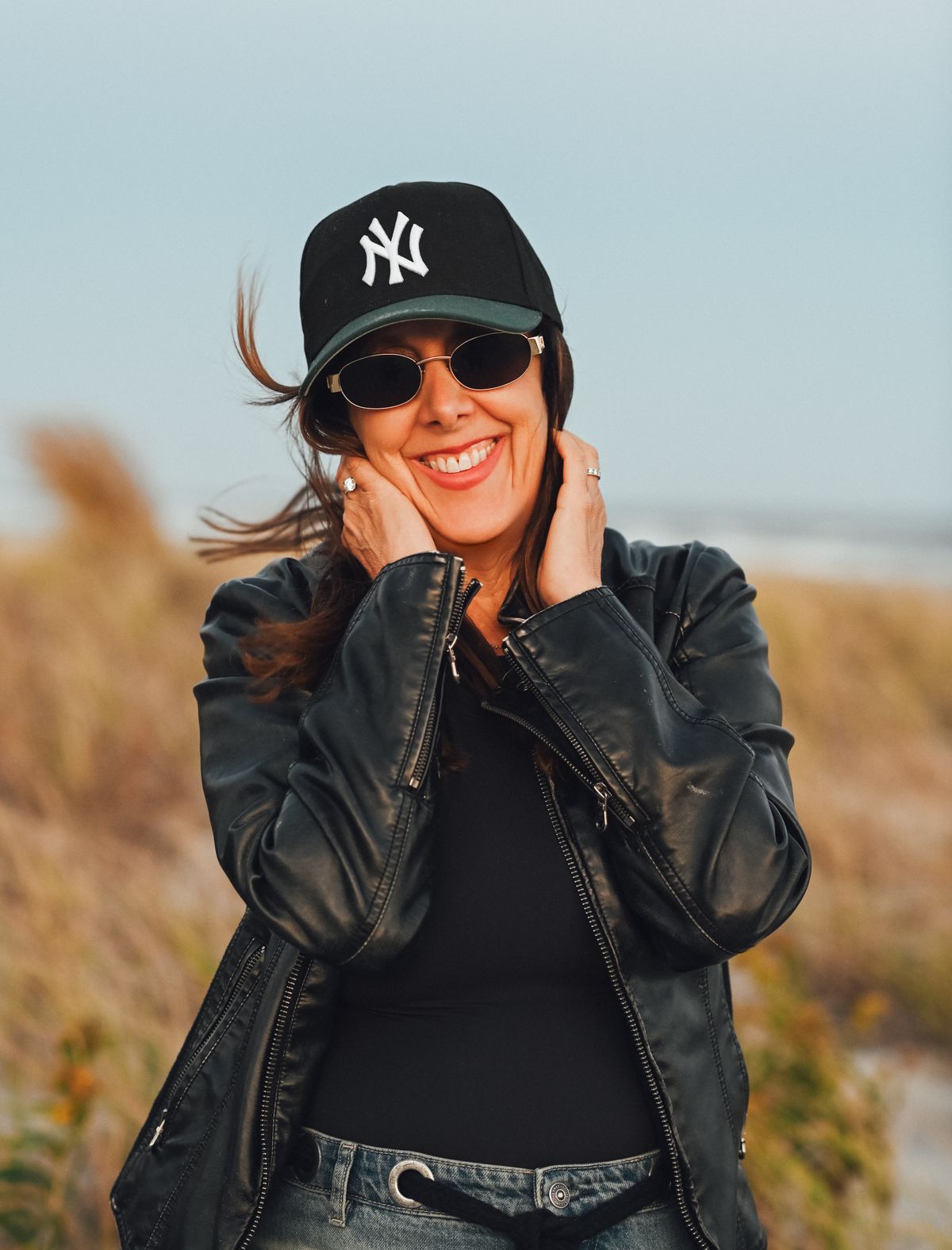 Helene laughing on the beach in a Yankees cap